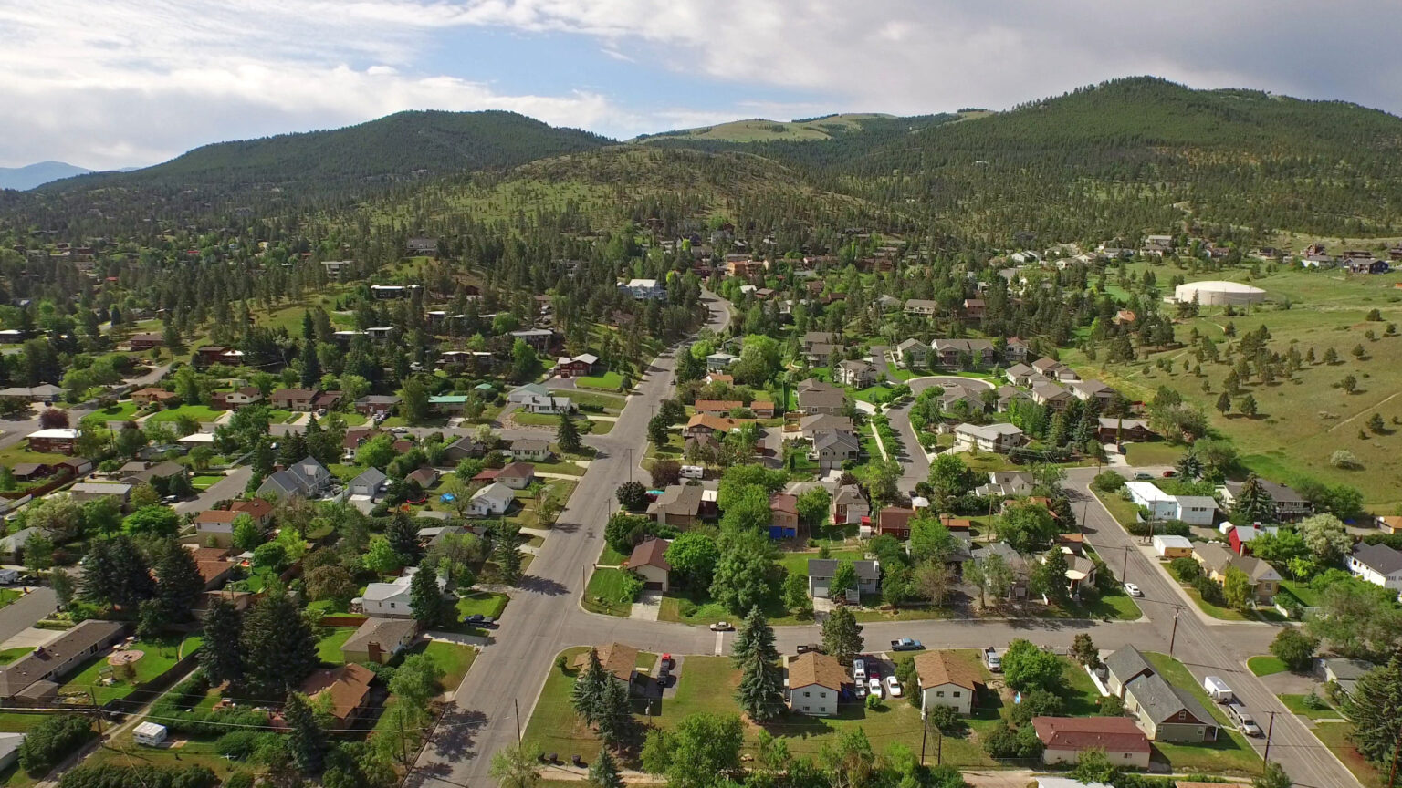 Scenic aerial view of a mountain neighborhood, highlighting Billings MT real estate and its natural surroundings.